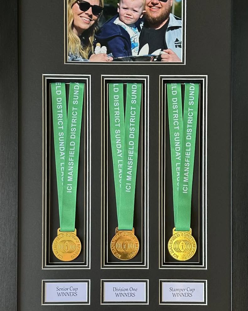Three framed Mansfield Sunday League winners' medals with family photograph
